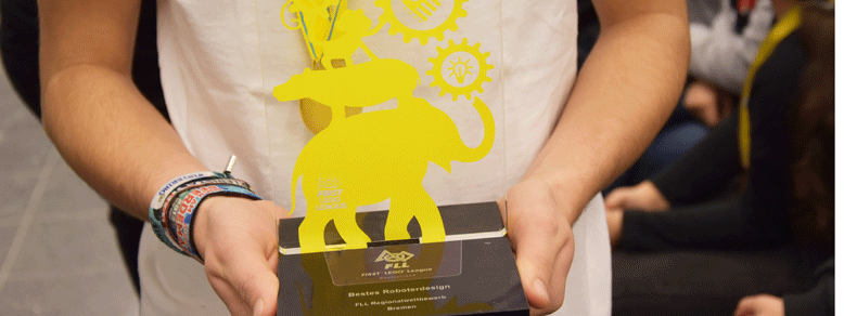 Eine Person hält mit beiden Händen einen Award für das beste Roboterdesign