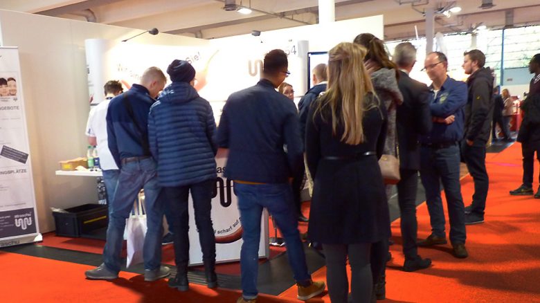 Auf der Jobmesse stehen viele Besucher vor dem straschu Stand