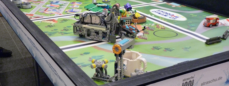 Auf einem Tisch stehen Roboter und Maschinen aus Lego gebaut.