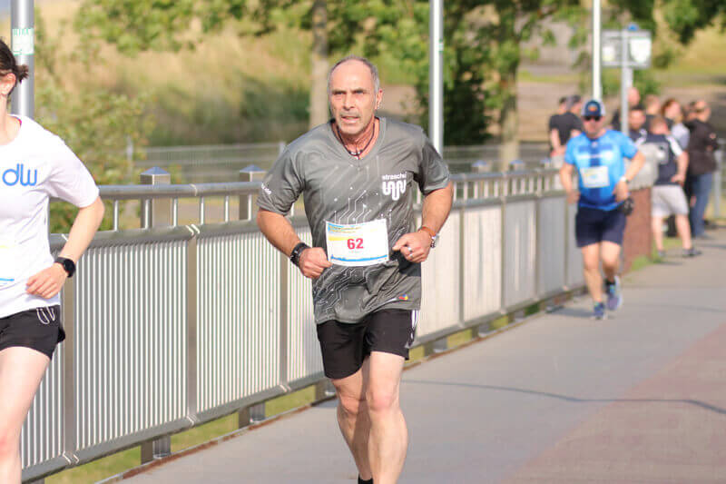 Ein Mann läuft beim Firmenlauf für straschu.