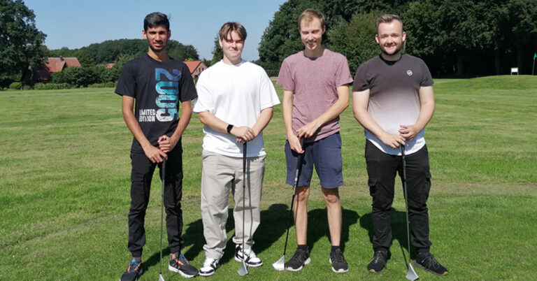 Vier Auszubildende beim Ausflug auf dem Golfplatz