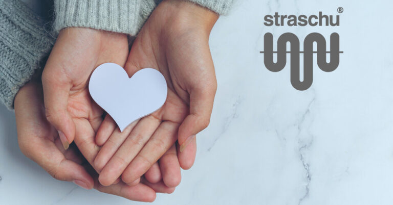 Zwei Paar Hände halten zusammen ein weißes Herz