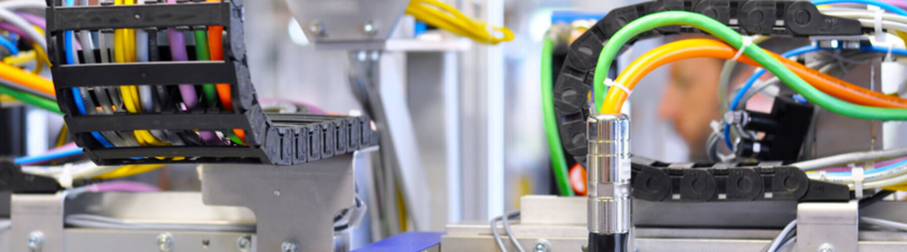 Sliderbild von verschieden bunten Kabeln und dem Kabelverlegsystem