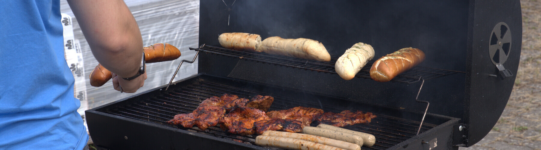 Ein Grill mit Fleisch und Brötchen