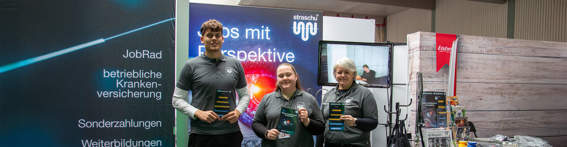 Gruppenbild mit drei Menschen im Firmen-T-Shirt am straschu Messestand