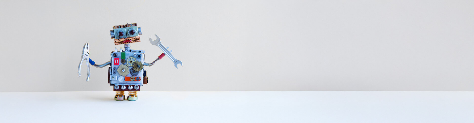 Ein grauer Hintergrund, vor dem ein kleiner Roboter ist, der bei straschu ein Praktikum macht.