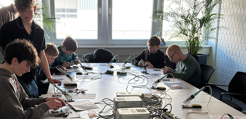 Eine Gruppe Kinder lötet am Zukunftstag bei straschu