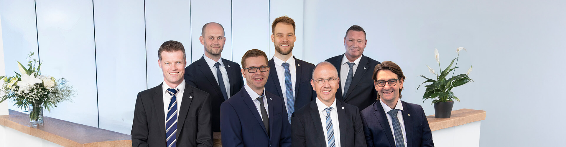 Gruppenbild des Vorstands der straschu Gruppe mit acht Männern im Anzug