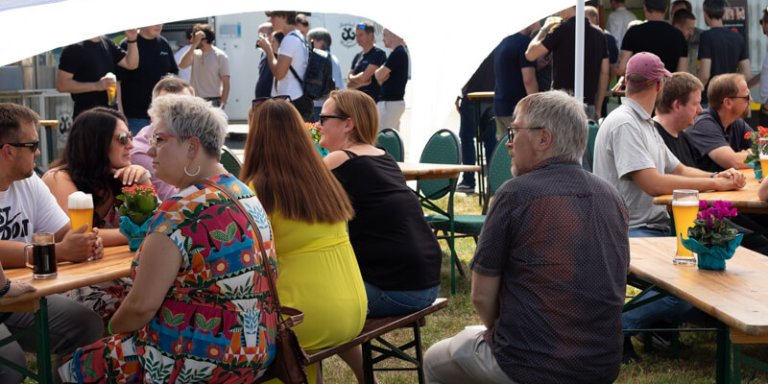 Mitarbeiter sitzen beim Griullfest zusammen.